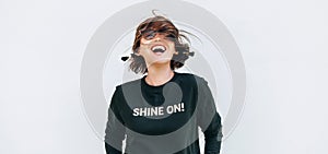 Free feeling happy woman posing in black sweatshirt with positive print Shine On