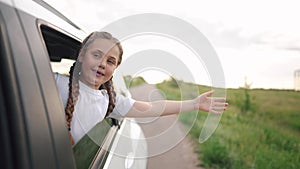 free girl child hand from the window rides in a car wind in the face. conceptual journey of a car on the road. The child