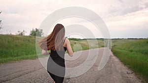 a free girl runs in the morning along the asphalt road. doing sports healthy concept. pretty girl running on asphalt