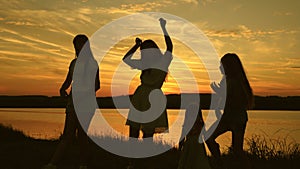 Free Happy girls dancing on beach. A party by the lake, children and mom are dancing. Healthy happy family is dancing on