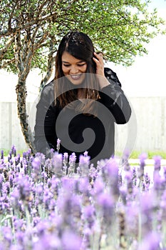 Free, happy, Latin adult woman in harmony and freedom, amid lavender flowers enjoying their beauty and aroma in a moment of relaxa