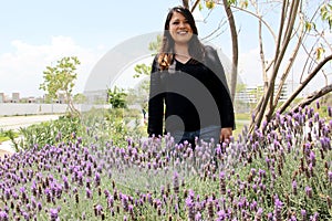 Free, happy, Latin adult woman in harmony and freedom, amid lavender flowers enjoying their beauty and aroma in a moment of relaxa