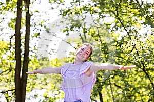 Free Happy Woman Enjoying Nature in a forest. Beauty Girl Outdoor. Freedom concept. Beautiful attractive Girl over Sky