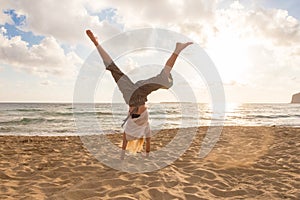 Free Happy Woman Turning Cartwheel Enjoying Sunset on Sandy Beach.