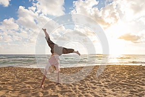 Free Happy Woman Turning Cartwheel Enjoying Sunset on Sandy Beach.