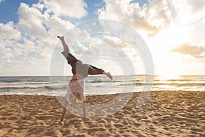 Free Happy Woman Turning Cartwheel Enjoying Sunset on Sandy Beach.