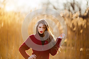 Free happy young woman. Beautiful female with long healthy blowing hair enjoying sun light in park at sunset. Spring