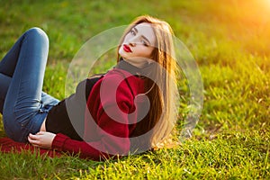 Free happy young woman. Beautiful female with long healthy hair enjoying sun light in park at sunset. Spring, autumn