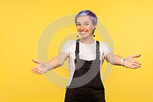 Free hugs! Portrait of kind generous hipster girl welcoming with raised hands and going to embrace. studio shot