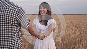 Free man and woman travel in field holding hands. Follow me, young happy couple running across golden wheat field