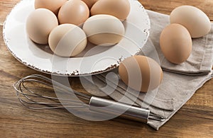 Free range eggs in bowl, whisk, napkin.