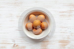 Free-range organic brown eggs in bowl on wood background with copy space