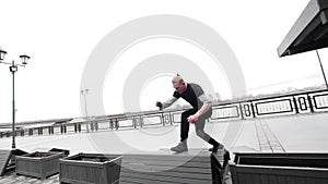 A free run - a tracer blonde man jumps a flip at park, parkour