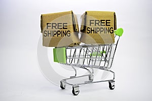 Free Shipping Text in small boxes and shopping cart. Concepts about online shopping. Isolated on white background