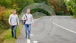 Free way to travel. Travel and hitch-hiking. twins walking along road. hitch hiking empty road. travelling by