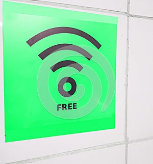Free Wi-Fi zone symbol, green sign on a white wall in a public empty space