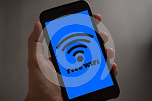 Free wifi sign concept. Hand holding mobile phone with free wifi