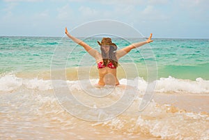 Free woman in hat enjoying freedom feeling happy at beach of sea