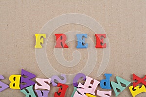 FREE word on wooden background composed from colorful abc alphabet block wooden letters, copy space for ad text. Learning english