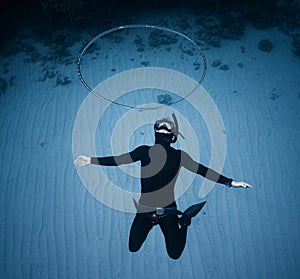 Freediver haves fun and blows the ring bubble underwater