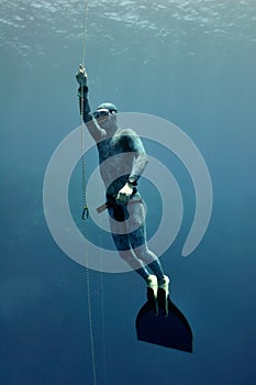 Freediver raises from the depth by rope