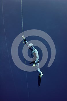 Freediver raises from the depth by rope