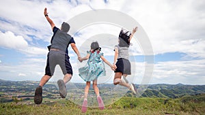 Freedom active family jumping at the top of mountain
