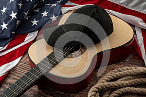 Freedom and american country and blues music festival concept with USA flag and acoustic guitar with a black cap on top and cowboy