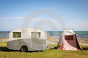 Freedom camping in vintage caravan and tent at an East Coast beach, Gisborne, North Island, New Zealand