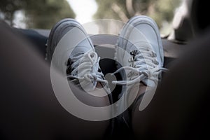 Freedom car travel concept - woman relaxing with feet on dashboard wearing white sneakers. Sexy woman in the car.