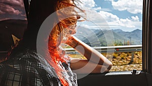 Freedom car travel concept - young woman relaxing out of window