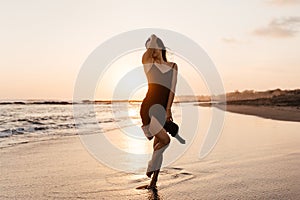 Freedom Chinese woman feeling free dancing at beach sunset.