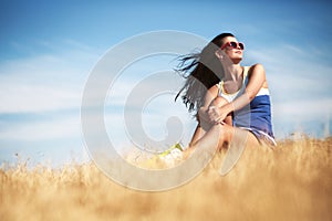 Freedom concept. Beautiful woman enjoying summer sun in the field