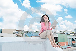 Freedom concept. Enjoyment. Asian young woman relaxing under blu