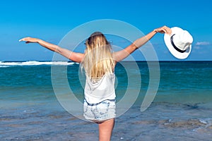 Freedom concept. woman on a beach of Bali island. She is enjoying serene ocean nature during travel holidays