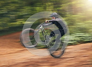 Freedom, energy and bike with adrenaline cyclist training in nature, practice extreme jumping trick on dirt road