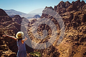 Freedom female wanderlust standing with raised hands enjoying majestic mountain landscape. Hipster young girl explore world. Summe