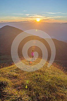 Freedom girl with hands up in the mountains