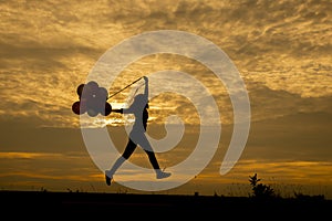 Freedom hand,Release and Let it go concept.Silhouette of a woman jumping with balloons with sunset backgroundThailand.Birthday photo