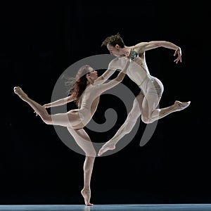 Freedom. Impressive young man and woman, talented, professional dancers performing ballet art against black studio