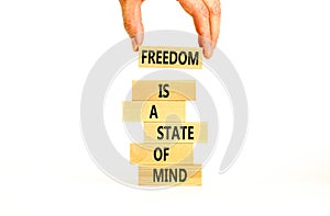 Freedom in mind symbol. Concept words Freedom is a state of mind on wooden block. Beautiful white table white background.