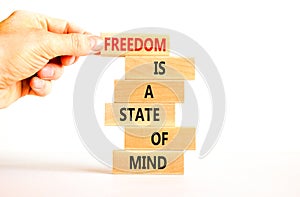 Freedom in mind symbol. Concept words Freedom is a state of mind on wooden blocks on a beautiful white table white background.