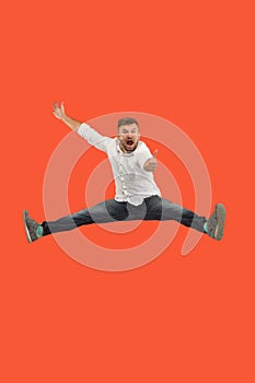 Freedom in moving. handsome young man jumping against orange background