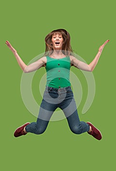 Freedom in moving. Pretty young woman jumping against orange background