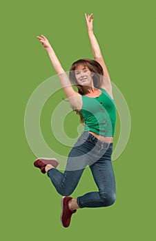 Freedom in moving. Pretty young woman jumping against orange background