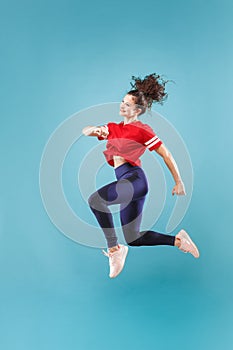 Freedom in moving. Pretty young woman jumping against pink background