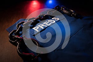 Freedom of the press and journalism concept. Blue journalist (press) vest in dark with backlight and fog. Selective focus