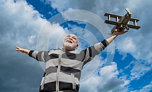 freedom of senior man on sky background. senior man at retirement. senior retired man with toy plane