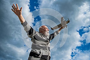 freedom of senior retired man. mature man at retirement. old man on sky background with toy plane