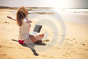 Freedom for smart working and digital nomad people lifestyle - happy free woman sitting on the sand beach work with 5g internet